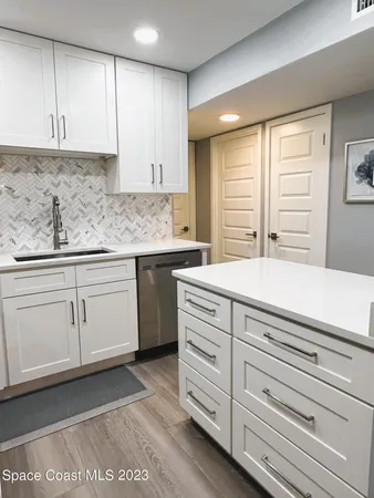 a kitchen with granite countertop white cabinets and white appliances