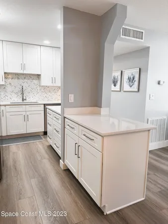 a kitchen with granite countertop white cabinets and white appliances