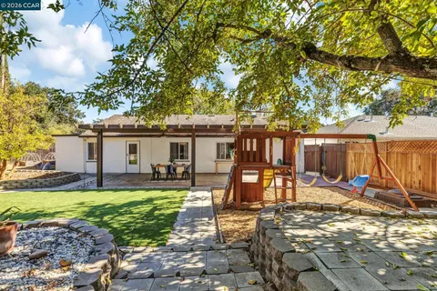 a view of a house with backyard and sitting area