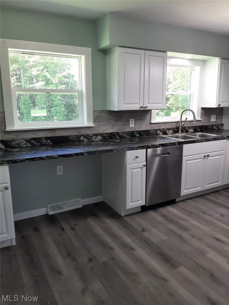 3139 Chapel Road Ashtabula, OH 44004 - Photo 5 of 7 Kitchen featuring stainless steel dishwasher, dark countertops, white cabinets, dark hardwood floors, and backsplash