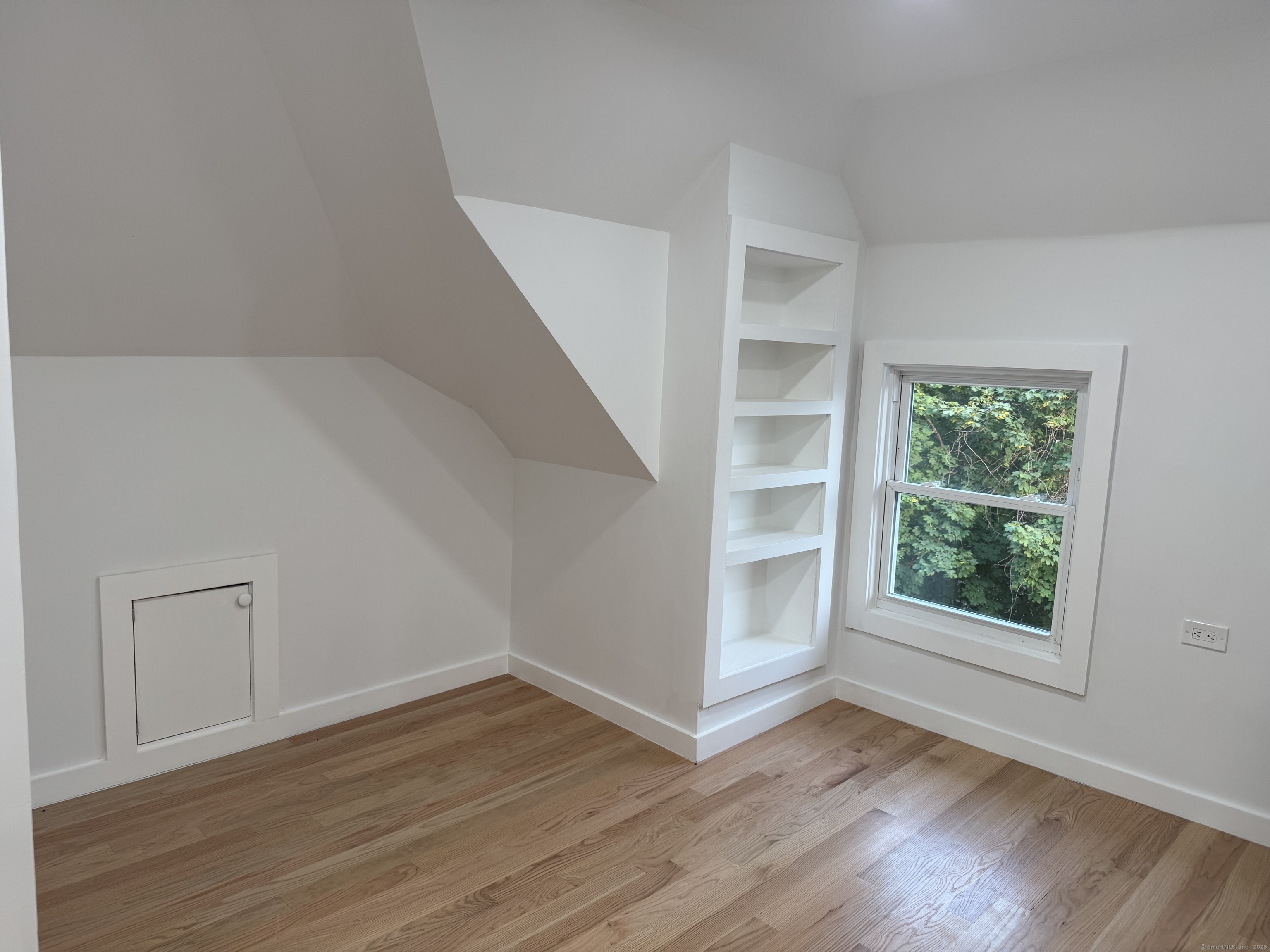 263 Hawley Avenue Bridgeport, CT 06606 - Photo 17 of 19 a view of an empty room with a window and wooden floor