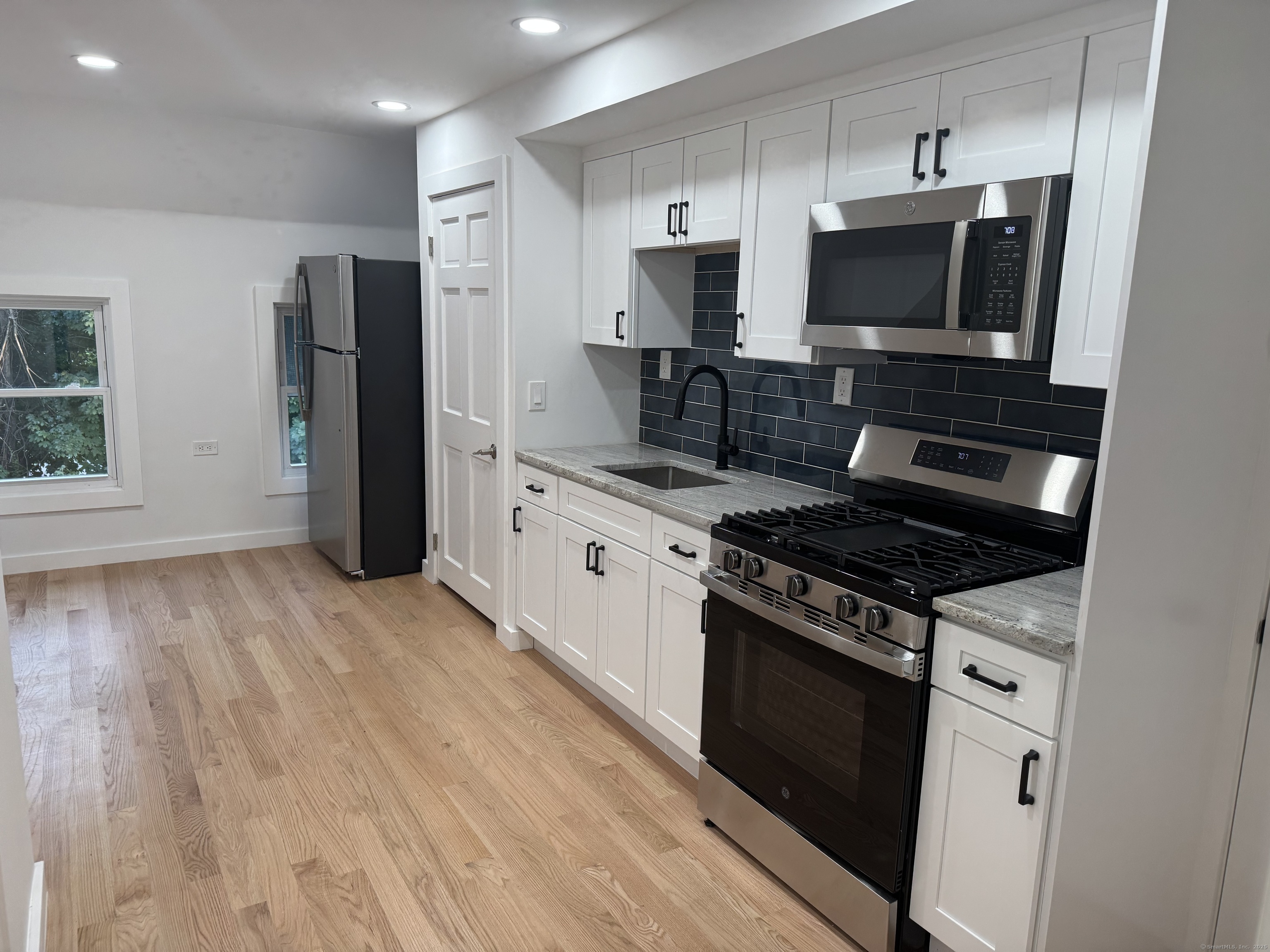 263 Hawley Avenue Bridgeport, CT 06606 - Photo 2 of 19 a kitchen with stainless steel appliances a stove a microwave and a hard wood floors