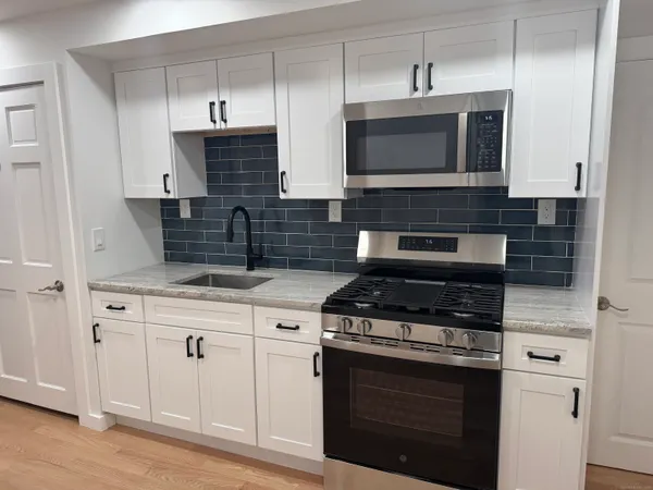 a kitchen with stainless steel appliances granite countertop a stove and a microwave
