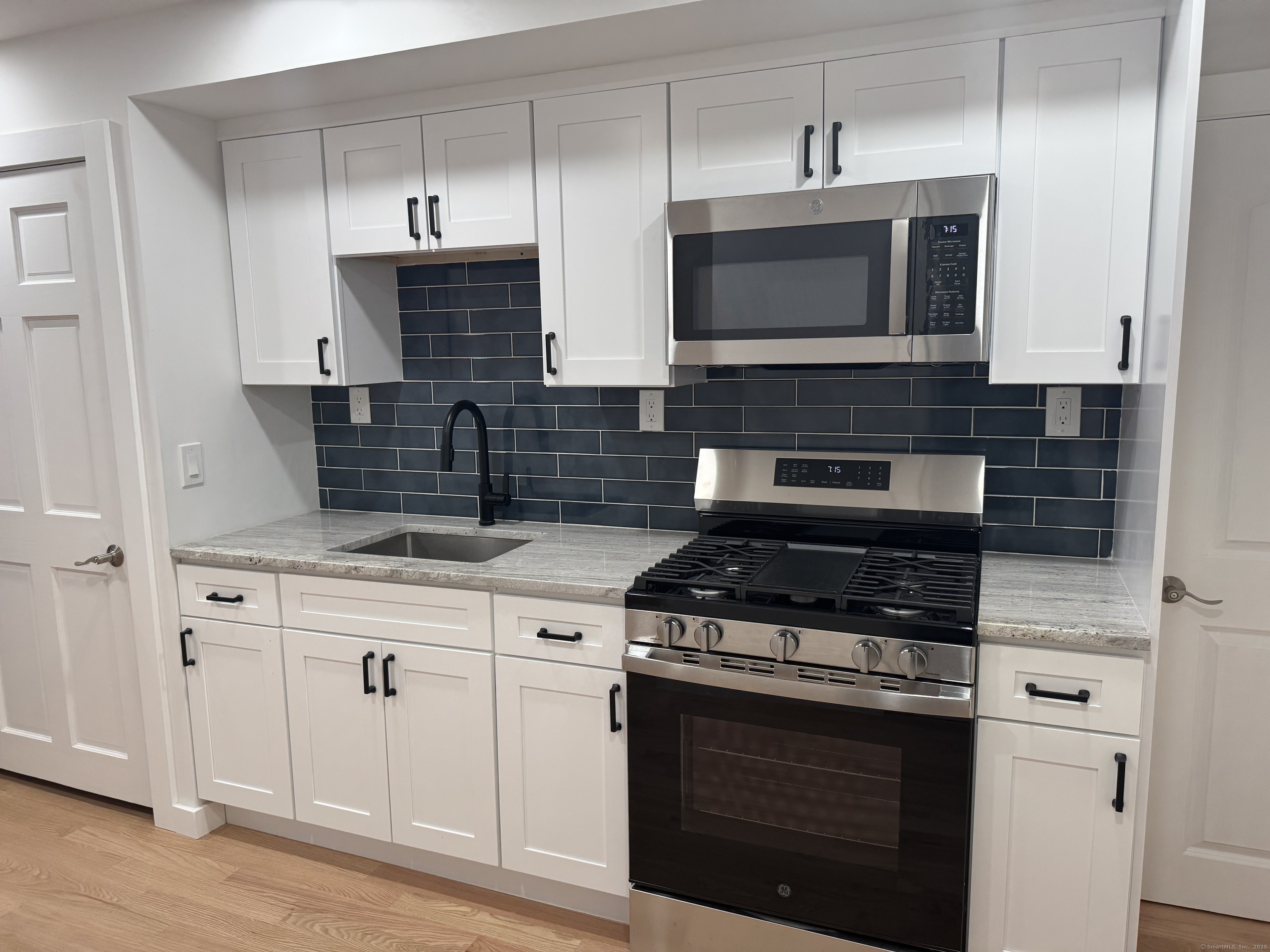 263 Hawley Avenue Bridgeport, CT 06606 - Photo 4 of 19 a kitchen with stainless steel appliances granite countertop a stove and a microwave