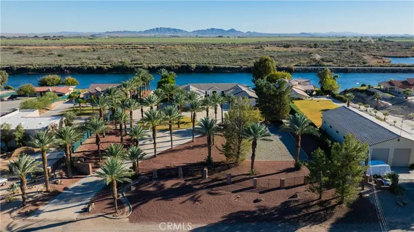 an aerial view of a house with a garden and lake view