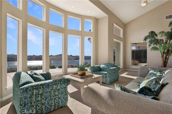 a living room filled with furniture and floor to ceiling windows