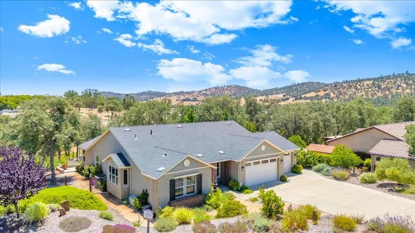 an aerial view of a house with a yard and lake view