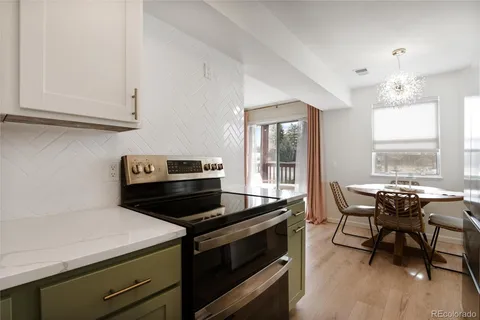 a kitchen that has a stove and a table chair in it