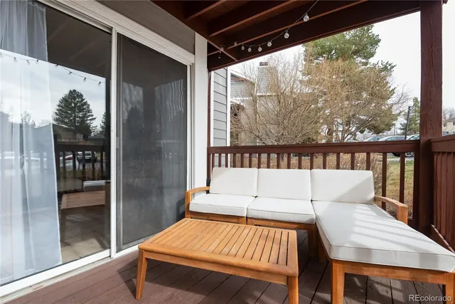 a outdoor sitting area with furniture and wooden floor