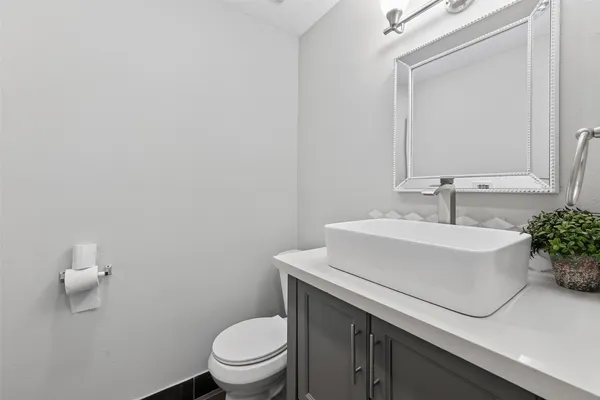 a bathroom with a sink a toilet and mirror
