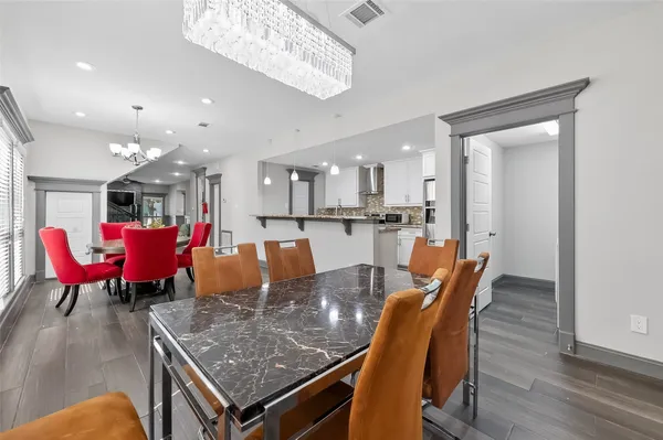 a dining room with a table chairs and kitchen view