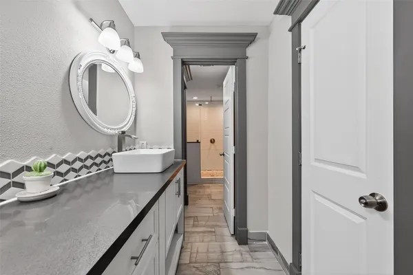 a bathroom with a granite countertop sink a mirror and a shower