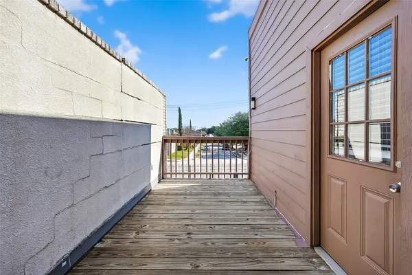 a view of a balcony with wooden floor and fence