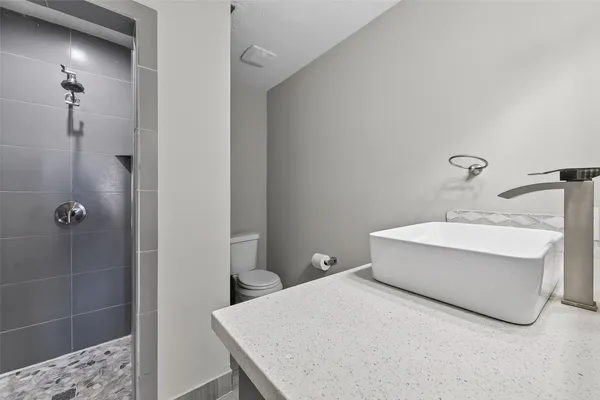 a bathroom with a sink a toilet and shower