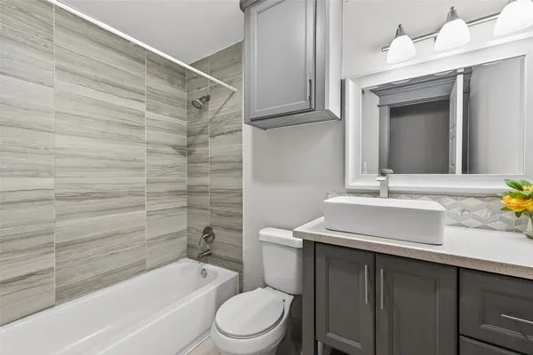 a bathroom with a sink toilet vanity and bathtub