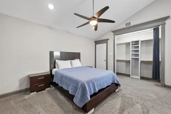 a bedroom with a bed and a ceiling fan