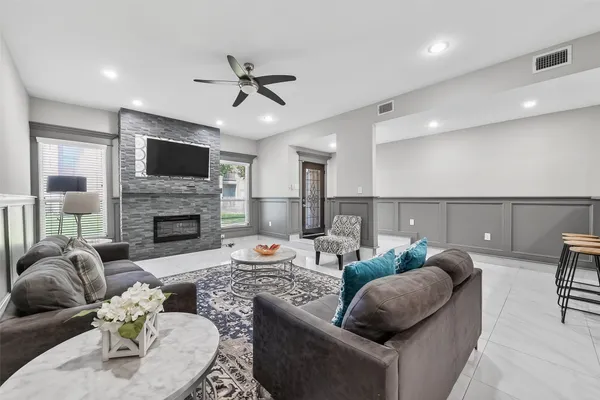 a living room with furniture a fireplace and a flat screen tv