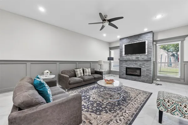 a living room with furniture a fireplace and a flat screen tv