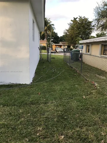 a view of house with backyard outdoor seating and green space