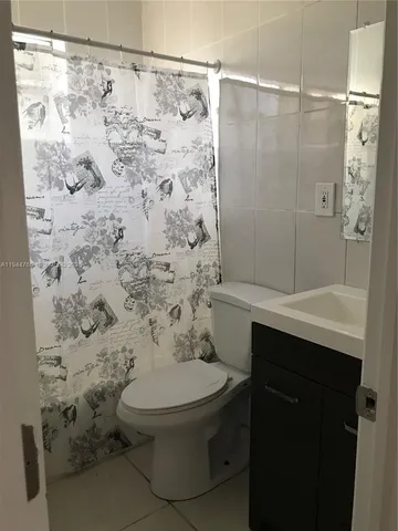 a bathroom with a sink a toilet and shower curtain