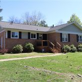a front view of a house with yard and green space