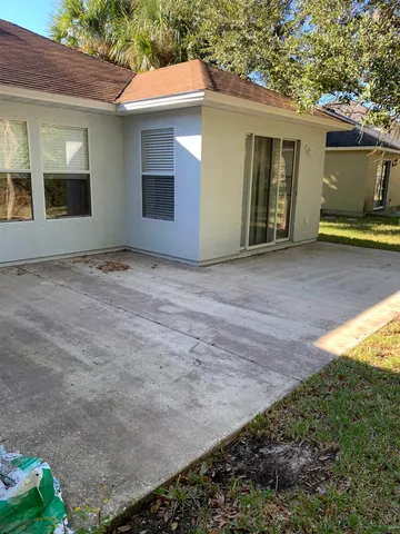 a backyard of a house with plants and tree