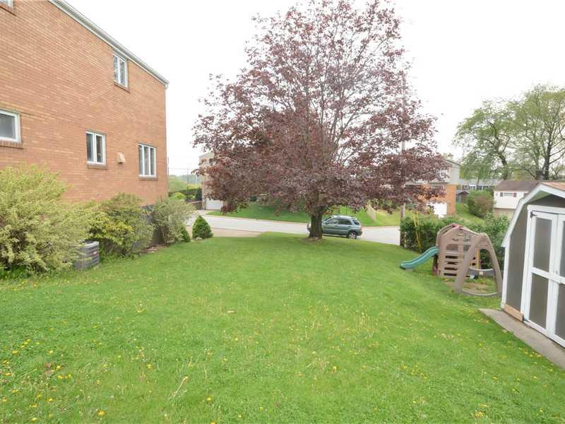 1305 Cathell Road Baldwin, PA 15236 - Photo 22 of 23 Yard/Garden. The generously sized side yard is shown in this view. The driveway leading to the integral 1-car garage is visible at the top center of the photo.