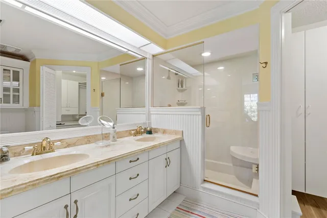 a spacious bathroom with a granite countertop sink a toilet a shower and a mirror