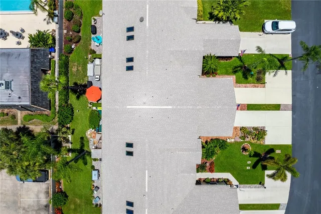 an aerial view of a house with a yard and a large pool