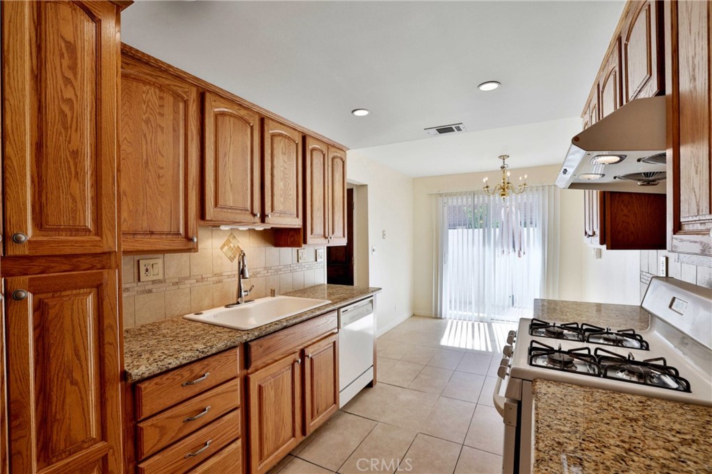 11557 Lower Azusa Road, Unit D El Monte, CA 91732 - Photo 11 of 38 a kitchen with stainless steel appliances granite countertop a stove a sink and a refrigerator