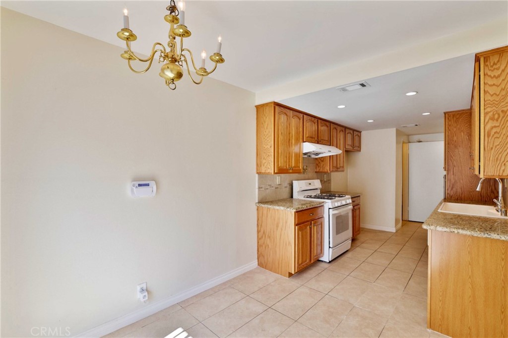 11557 Lower Azusa Road, Unit D El Monte, CA 91732 - Photo 13 of 38 a kitchen with a stove a refrigerator and a sink