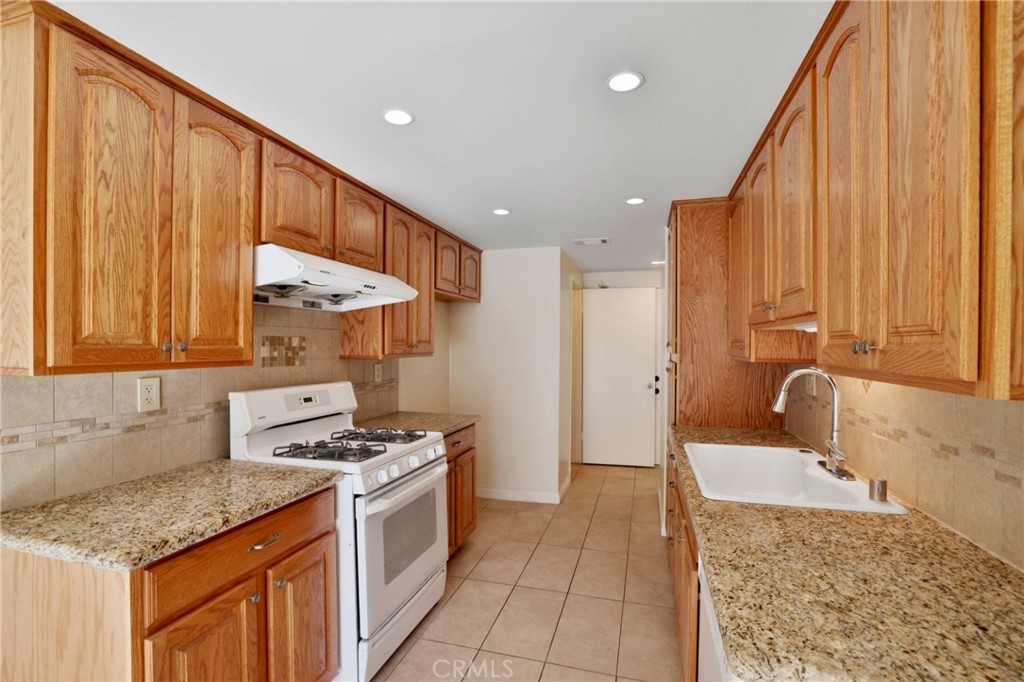 11557 Lower Azusa Road, Unit D El Monte, CA 91732 - Photo 10 of 38 a kitchen with stainless steel appliances granite countertop a sink a stove and a wooden cabinets