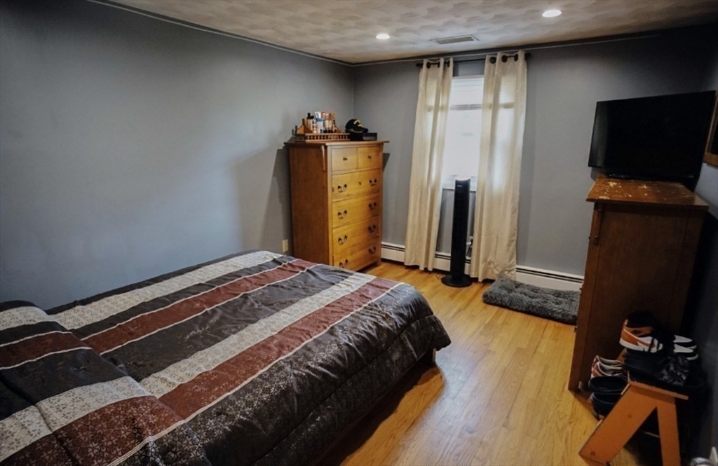 63 Wing Road Acushnet, MA 02743 - Photo 12 of 26 a bedroom with a bed and a flat tv screen on the dresser