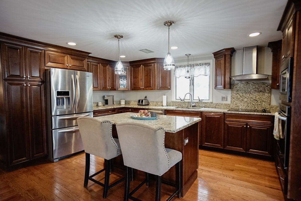 63 Wing Road Acushnet, MA 02743 - Photo 5 of 26 a kitchen with stainless steel appliances granite countertop a refrigerator a sink dishwasher a stove and white countertops with wooden floor