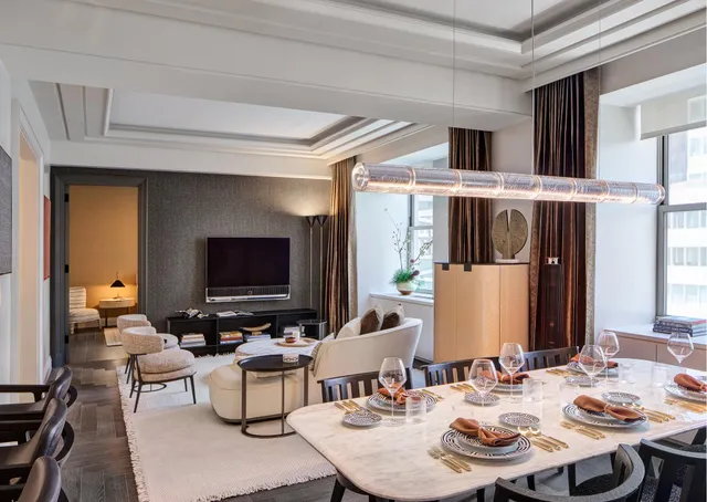 a living room with furniture kitchen view and a flat screen tv