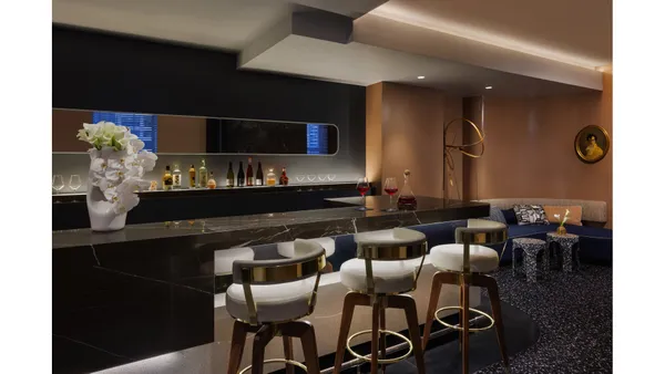 a dining hall with furniture and a kitchen view