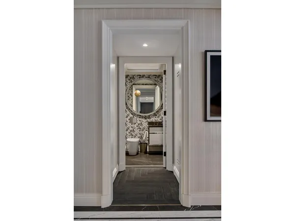 a view of a hallway with wooden floor and a living room