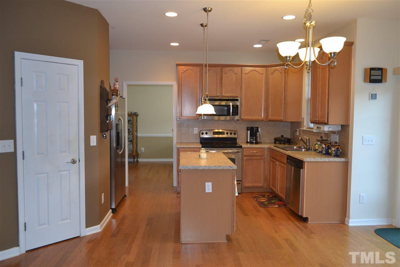 1421 Reynolds Mill Road Wake Forest, NC 27587 - Photo 3 of 18 Great space for cooking and entertaining. Island with storage, pendant lights, large walk-in pantry, SS appliances, recessed lights, access to over side patio area through glass sliders. Extend your entertaining area to the fenced in area outdoors!