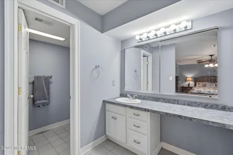 a bathroom with a granite countertop sink a mirror and a shower