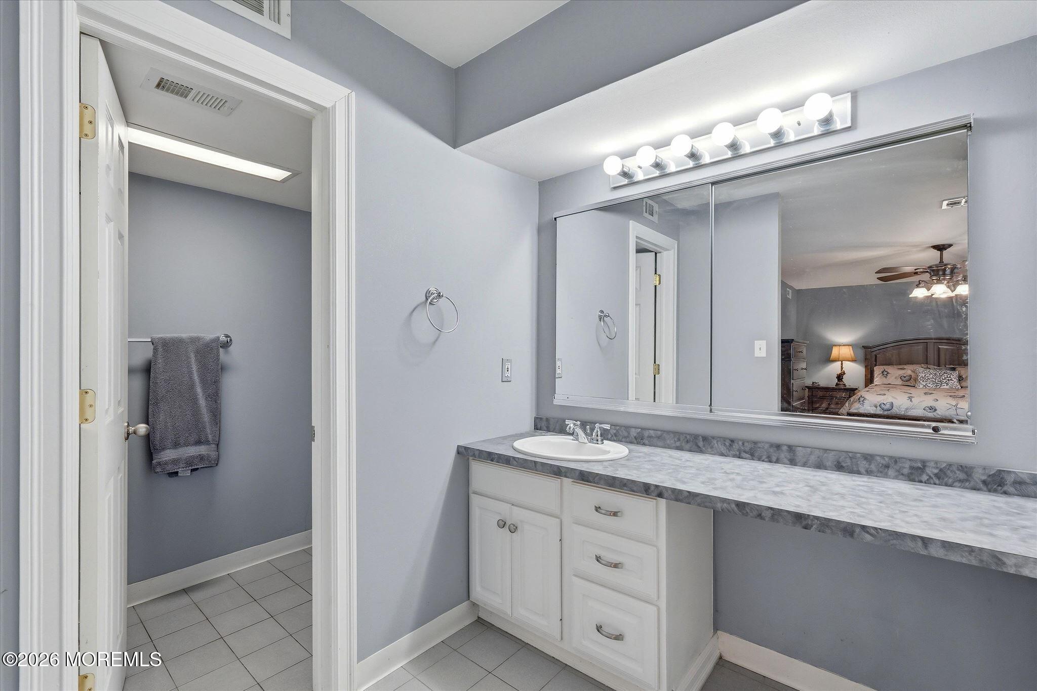 22 Ethan Allen Road Freehold, NJ 07728 - Photo 24 of 31 a bathroom with a granite countertop sink a mirror and a shower