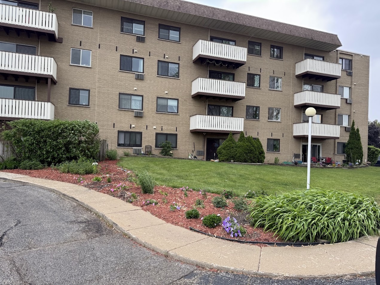 290 North Westgate Road, Unit 401 Mount Prospect, IL 60056 - Photo 1 of 15 a view of a white house with a big yard and potted plants