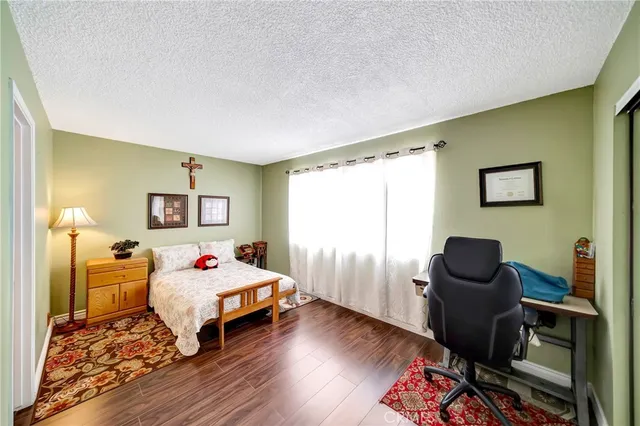 a bedroom with a bed and wooden floor
