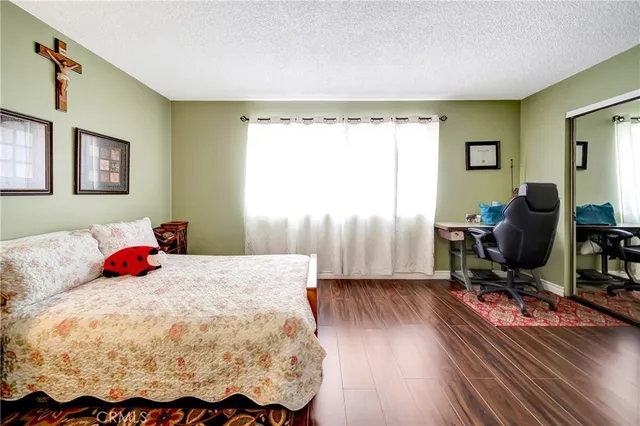 a bedroom with a bed and wooden floor
