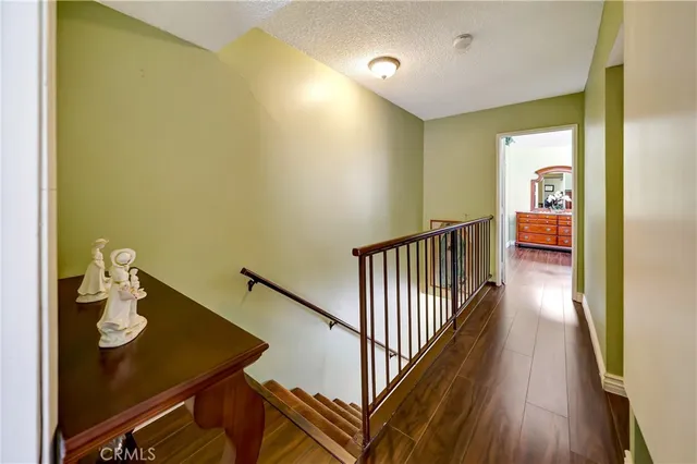 a view of a hallway with wooden floor and dining room