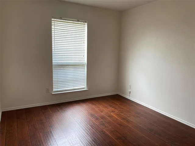 an empty room with wooden floor and a window