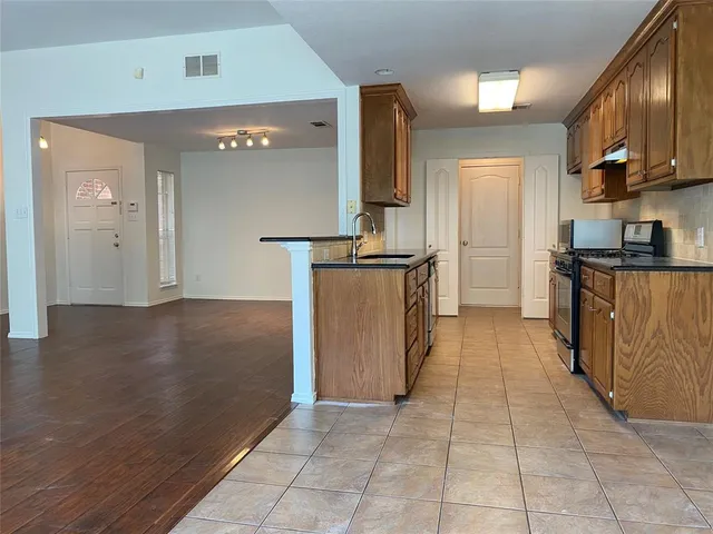 a kitchen with stainless steel appliances granite countertop a refrigerator and a stove