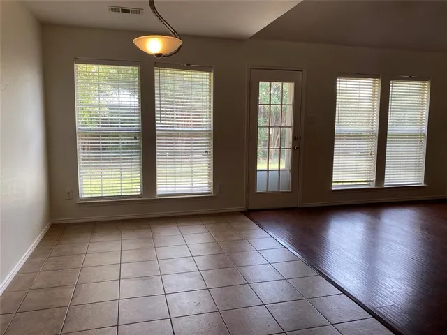 a view of an empty room with glass door and windows
