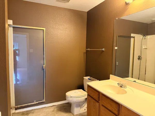 a bathroom with a sink a toilet and shower