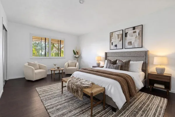 a bedroom with bed couch and window