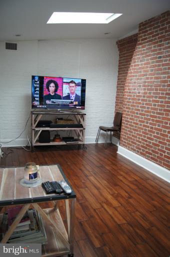 719 Anneslie Road Baltimore, MD 21212 - Photo 16 of 30 Family Room with exposed brick wall, hardwood.